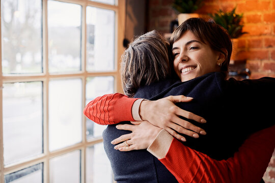 Couple embracing and kissing hello in a London coffee shop