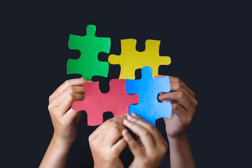 Adult and Child Hands Holding Jigsaw Puzzle Heart Shape. Autism Spectrum Disorder Family Support.