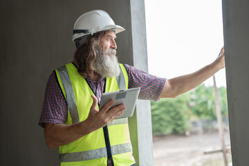 Engineer builder. Foreman use tablet computer working in construction site. senior worker project designer leader concept.	