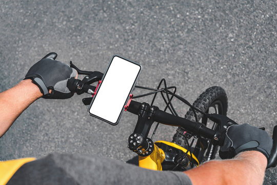Close-up mockup of a smartphone on a bicycle handlebar. Asphalt road background.