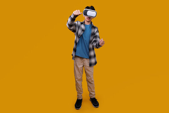 Fototapeta Full Body of Asian Little Boy Experiencing Virtual Reality Glasses Isolated on Yellow Background
