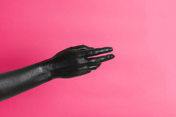 Black painted elegant woman's hand on her skin gesticulates on pink background. High Fashion art...