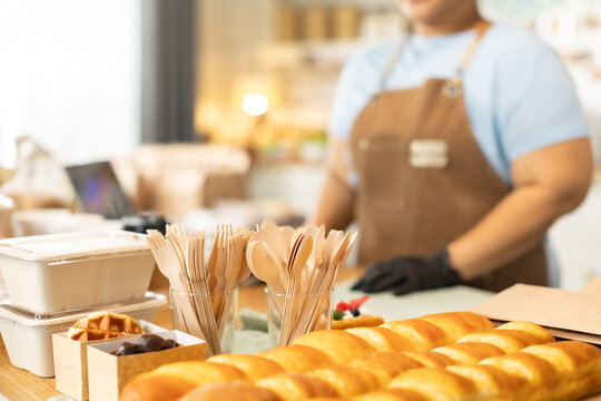 Small business owners are selling .Handsome young caucasian waiter servicing the customer with swiping machine in a cafe. Cashless contactless payment with credit debit card. E-banking .