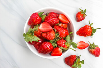 a bowl of strawberries on a ceramic floor as a background
