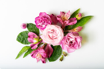 Beautiful bouquet featuring vibrant pink and purple flowers with water droplets, surrounded by lush green leaves