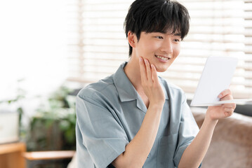 Obraz premium 部屋の中で鏡を見ている20代の日本人男性