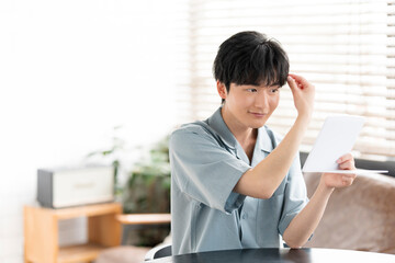 部屋の中で鏡を見ている20代の日本人男性