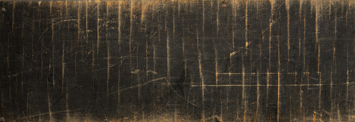 The long wooden surface is black.The texture of scratched wood with visible scratches and signs of wear