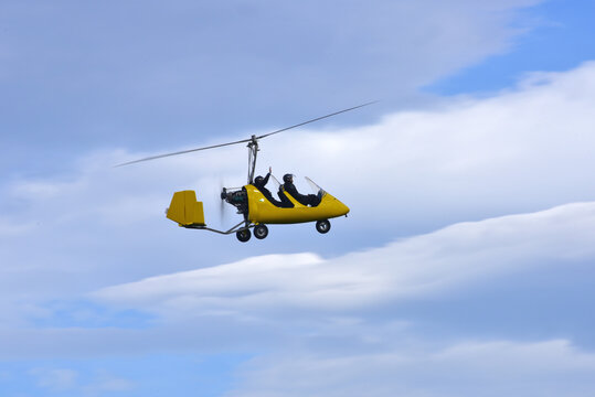 Gyrocopter flying with background of blue sky