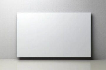 Blank white rectangular surface against a light gray wall