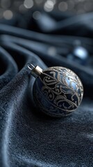 Fototapeta premium Festive Ornament Amidst Silken Drapery: An elegant Christmas bauble, with intricate detail, rests upon a luxurious blue silk, creating a sophisticated and atmospheric holiday scene.