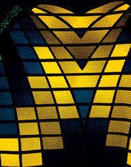 bold geometric pattern with symmetrical yellow and blue rectangles and triangles. The contrasting...
