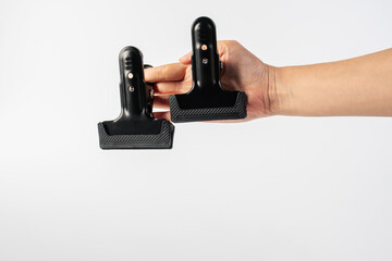 Black plastic spring clamp in hand isolated on white background.