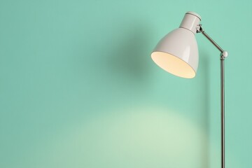 Sleek modern lamp glowing softly against pastel mint green wall