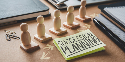 Wooden figurines arranged in a line, representing succession planning, alongside a sticky note with the text "Succession Planning", symbolizing leadership transition and business continuity