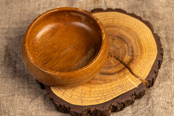wooden bowl on a stand on a linen tablecloth, an empty food bowl on the table is made of acacia wood