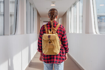View of female tourist with backpack inside a jet bridge