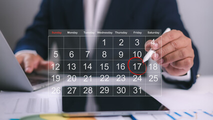 Calendar for monthly appointments and planning, Managing his business schedule, Setting reminders for important appointments, Agenda plan and schedule event, A pen marking dates on virtual calendar.