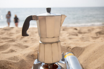 geyser coffee maker brews coffee on portable gas stove on seashore