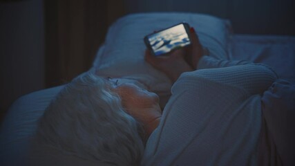 woman suffers from insomnia lying in bed using smart phone before sleep, dark night room. light from affects eyes face. lady scrolling social media app Phone screen holding mobile in hands. old age - Powered by Adobe