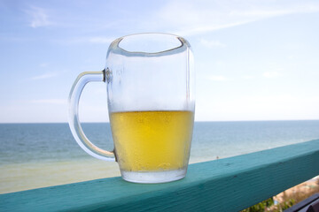 Glass of beer with sea in background
