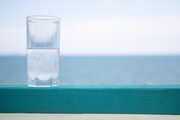 Glass of drink by the water