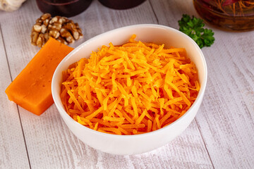 Yellow shredded cheddar cheese in the bowl