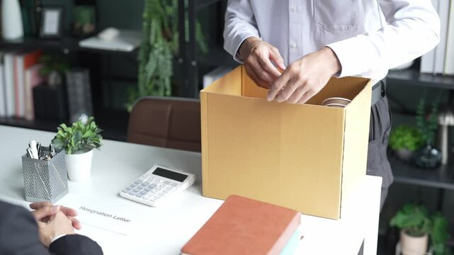 Employees put things in boxes in the office. After resigning from work