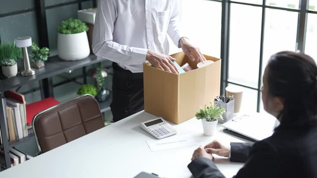 Employees put things in boxes in the office. After resigning from work
