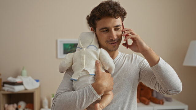 Young man holding baby and talking on phone in cozy bedroom setting at home, showcasing tender moment of a father in an intimate indoor environment. - Powered by Adobe
