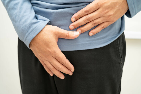 Hernia, Asian man stomach ache, abdominal pain and urology problem health.