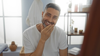 Smiling man indoors in a spa setting, highlighting a handsome, clean-shaven adult enjoying a...
