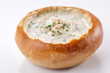 Freshly made clam chowder served in a warm bread bowl at a seaside restaurant during sunny afternoon