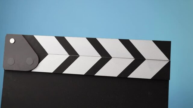 Clapperboard in motion, filmmaking scene, chalk dust flying as the board claps