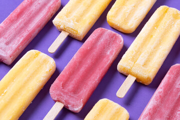 Red and yellow popsicles pattern on purple background