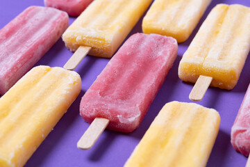 Red and yellow popsicles pattern on purple background