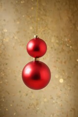 A single, shiny red Christmas ball ornament hangs from a thin, gold string against a blurred background , abstract, winter decoration