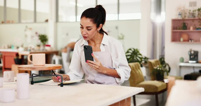 Pottery, art and woman with phone for picture for social media, online post and creative design. Studio, workshop and person on smartphone for photo of ceramic hobby, clay object and sculpture