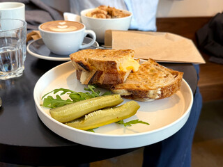 Grilled Craft Bread with Cheese, Arugula, and Pickles on Table. Modern Food Concept. Handmade Mobile Photo, Not AI