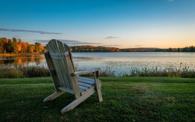 Fototapeta premium autumn Ontario, Canada, Empty Adirondack Chair Sunset Lakeside