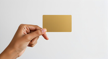 Close Up of Brown Skinned Hand Presenting Golden Card on Soft White Background for Financial and Identity Concepts