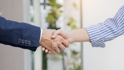 close up investor businessman handshake with businesswoman partner after finishing agreement or...