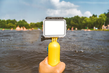Close-up Mockup of an action camera in a man's hand against the background of water and rain.