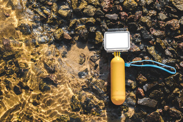 Close-up of a white action camera mockup with a waterproof body and a yellow float for swimming.