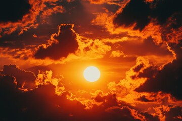 Dramatic orange sunset sky with sun and dark clouds