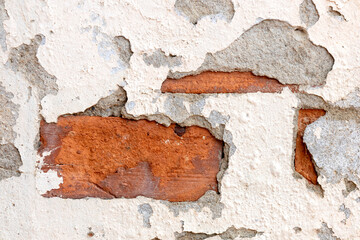 Old Wall with Peeling Plaster and Exposed Red Brick Texture