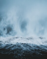 Naklejka premium Powerful ocean wave crashing on a rocky shore in Iceland dramatic moody seascape nature photography