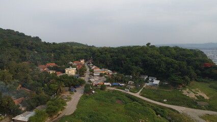 Tranquil aerial photograph captures the beauty of a charming rural village nestled amidst rolling hills and lush greenery.