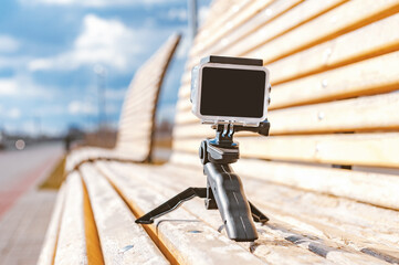 A small action camera stands on the benches. Background of clouds in the sky.
