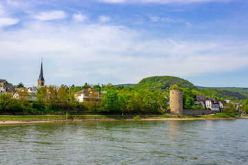 Cityscape of Rhens with medieval tower, church and surrounding landscape on the banks of the Rhine River, Germany